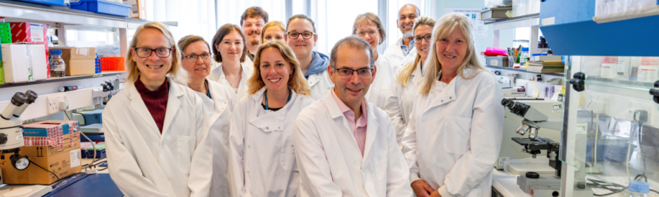 team of scientists in white lab coats 