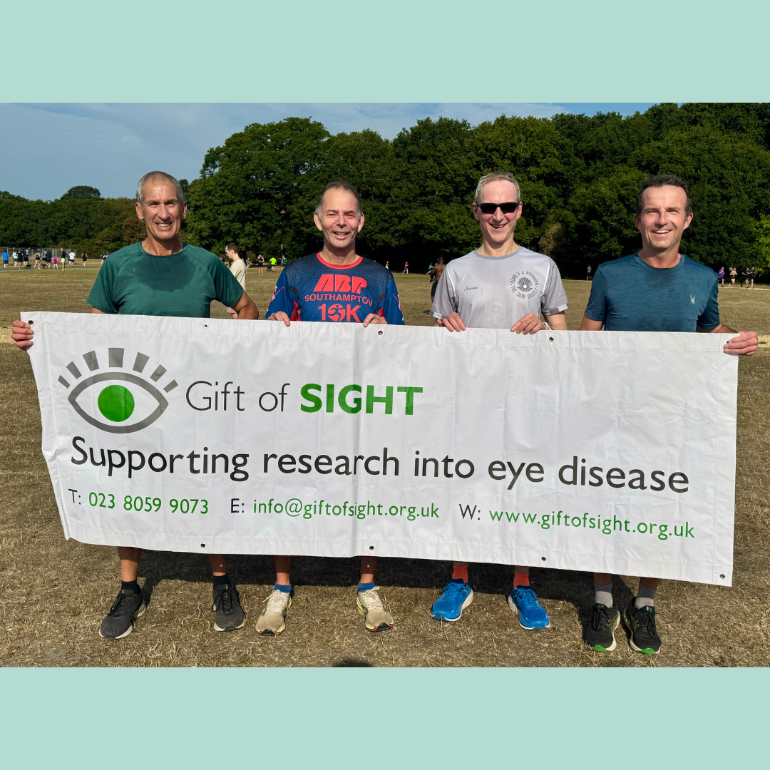 Professor Lotery's Relay Team standing in front of Gift of Sight banner