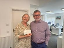Ailsa holding cheque next to David Simpson 